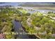Beautiful aerial view of the community's lagoon, trees, and townhomes near the creek and beach at 491 Sea Cloud Cir, Edisto Island, SC 29438
