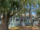 Inviting condo exterior with multiple balconies, large windows and lush, tropical trees at 491 Sea Cloud Cir, Edisto Island, SC 29438
