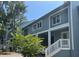 Charming two-story condo featuring inviting entrances with white railings and verdant landscaping at 491 Sea Cloud Cir, Edisto Island, SC 29438