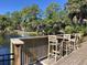Wooden deck overlooking a pond with fountain, furnished with tables and chairs for relaxing lakeside at 491 Sea Cloud Cir, Edisto Island, SC 29438