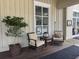 Inviting porch area with cushioned seating and a decorative potted tree offering a relaxing outdoor space at 491 Sea Cloud Cir, Edisto Island, SC 29438