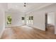 Bright bedroom with a tray ceiling, ceiling fan, hardwood floors, and views from multiple large windows at 499 Lackland Ct, Mount Pleasant, SC 29464