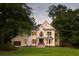 Beautiful two-story white brick home featuring a well-manicured lawn, large trees, and eye-catching architectural details at 499 Lackland Ct, Mount Pleasant, SC 29464