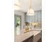 Kitchen island featuring a farmhouse sink, brass faucet, and stylish pendant lighting at 499 Lackland Ct, Mount Pleasant, SC 29464