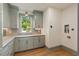 Well-lit laundry room featuring shaker cabinets, marble countertop, and modern faucet at 499 Lackland Ct, Mount Pleasant, SC 29464