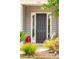 Inviting front entrance featuring a stylish black door, charming decor, and lush landscaping at 516 Tidewater Chase Ln, Summerville, SC 29486