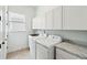 Bright laundry room with tile flooring, sink, and white washer and dryer beneath cabinetry at 516 Tidewater Chase Ln, Summerville, SC 29486
