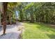 Spacious backyard featuring a lush lawn and mature trees, perfect for outdoor activities at 5488 Altamaha Dr, North Charleston, SC 29420