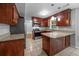 Spacious kitchen featuring granite countertops, dark wood cabinets, stainless steel appliances and tile floors at 5488 Altamaha Dr, North Charleston, SC 29420