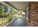 Inviting porch with brick accents, white railings, and lush landscaping adds charm to the home at 5488 Altamaha Dr, North Charleston, SC 29420