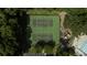 Aerial view of community tennis courts surrounded by lush trees and foliage, next to playground, pool and parking at 5488 Altamaha Dr, North Charleston, SC 29420