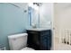 Powder blue bathroom with a black vanity, bright lighting, chrome fixtures, and a white commode at 655 Swinton Ct, Mount Pleasant, SC 29464