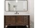 Bathroom vanity with dark wood cabinets, black hardware and a large framed mirror at 655 Swinton Ct, Mount Pleasant, SC 29464
