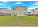 Well-manicured backyard with a view of the home's exterior, featuring solar panels and a fenced perimeter at 7675 High Maple Cir, North Charleston, SC 29418