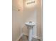 Small bathroom features a pedestal sink, tiled floor, and vanity lighting at 7675 High Maple Cir, North Charleston, SC 29418