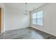 Dining area with a modern chandelier, large window with blinds and a grey wood-look floor at 7675 High Maple Cir, North Charleston, SC 29418