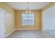 Bright dining room features tan walls, chandelier, and window providing plenty of natural light at 7675 High Maple Cir, North Charleston, SC 29418