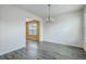Dining room with white walls, wood-look floors, a modern chandelier, and a bright window at 7675 High Maple Cir, North Charleston, SC 29418