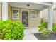 Cozy front porch with a decorative door, framed by sidelight windows and lush landscaping at 7675 High Maple Cir, North Charleston, SC 29418