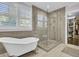 Bright bathroom featuring a soaking tub, glass shower, and natural light from shuttered windows at 828 Bridge Point Cir, Mount Pleasant, SC 29464