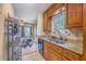 Well-lit kitchen with stainless steel sink, granite counters, and wooden cabinets at 851 Sandlake Dr # D, Mount Pleasant, SC 29464