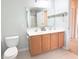 Bathroom features a double sink vanity, toilet, mirror, and doorway to a shower and bath area at 9229 N Moreto Cir, Summerville, SC 29485