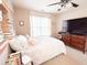 Bright bedroom with mounted TV and comfortable looking bed with decorative pillows at 9229 N Moreto Cir, Summerville, SC 29485