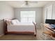 Bedroom features a wooden bed frame with pink accents, a desk, a ceiling fan, and neutral colored walls and carpet at 9229 N Moreto Cir, Summerville, SC 29485