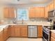 Kitchen features wooden cabinets, stainless steel appliances, a view of the backyard from above the double basin sink at 9229 N Moreto Cir, Summerville, SC 29485