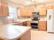 Bright kitchen with wooden cabinets, laminate countertop, stainless steel appliances, and a view of the backyard at 9229 N Moreto Cir, Summerville, SC 29485