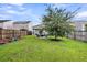 Large, grassy backyard featuring a fire pit area, a mature tree, and a wooden perimeter fence at 9712 Fanning Basket Ln, Ladson, SC 29456