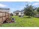 Spacious backyard with a fire pit, screened in porch, garden, mature tree and wooden fence at 9712 Fanning Basket Ln, Ladson, SC 29456