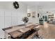 Dining area with a farmhouse table, decorative wainscoting, and an open view to the kitchen at 9712 Fanning Basket Ln, Ladson, SC 29456