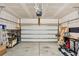 Well-lit two car garage with shelving, lawn equipment and an insulated garage door at 9712 Fanning Basket Ln, Ladson, SC 29456