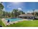 Community pool with ample lounge chairs and a nearby recreational building on a sunny day at 106 Chedburg Dr, Goose Creek, SC 29445