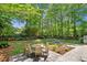 Well-maintained backyard with lush landscaping, patio area, and a charming fire pit seating arrangement at 1061 Law Ln, Mount Pleasant, SC 29464