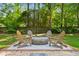 Inviting backyard fire pit featuring Adirondack chairs and a wooded perimeter for a cozy outdoor experience at 1061 Law Ln, Mount Pleasant, SC 29464