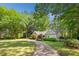 Charming front exterior of home with a circular driveway, mature trees, and lush landscaping at 1061 Law Ln, Mount Pleasant, SC 29464