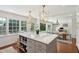 Spacious kitchen with a large center island, wooden stools, modern lighting and open view to the dining area at 1061 Law Ln, Mount Pleasant, SC 29464