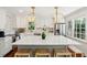 Bright kitchen features white cabinets, marble backsplash, stainless appliances, and an island with stools at 1061 Law Ln, Mount Pleasant, SC 29464