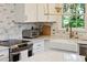 Close up of kitchen features farm sink, marble tile backsplash, stainless steel appliances and fixtures at 1061 Law Ln, Mount Pleasant, SC 29464