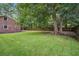 A large brick house with covered patio and expansive green backyard with mature trees at 110 Terry Ave, Summerville, SC 29485