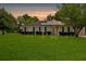 Charming single-story home with solar panels, lush lawn and manicured shrubs at dusk at 1101 Stuart Dr, Moncks Corner, SC 29461