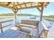 Waterfront property with a wooden dock featuring built-in seating and boat lift access at 1193 River Rd, Johns Island, SC 29455