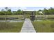 Waterfront dock features a covered structure and boat lifts amidst lush marshland at 1193 River Rd, Johns Island, SC 29455