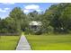 Marsh view of two-story home surrounded by lush greenery as seen from the boardwalk at 1193 River Rd, Johns Island, SC 29455
