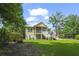 Classic architecture home with a lush green lawn, complemented by the surrounding mature trees at 1193 River Rd, Johns Island, SC 29455