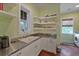 Bright laundry room with stainless steel countertops, a utility sink, modern cabinets, and lots of storage space at 1193 River Rd, Johns Island, SC 29455