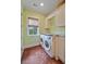 Bright laundry room with a modern washer and dryer set, plenty of cabinets, and a window for natural light at 1193 River Rd, Johns Island, SC 29455