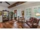 Cozy living room featuring hardwood floors, beamed ceilings, and a stylish leather armchair at 1193 River Rd, Johns Island, SC 29455